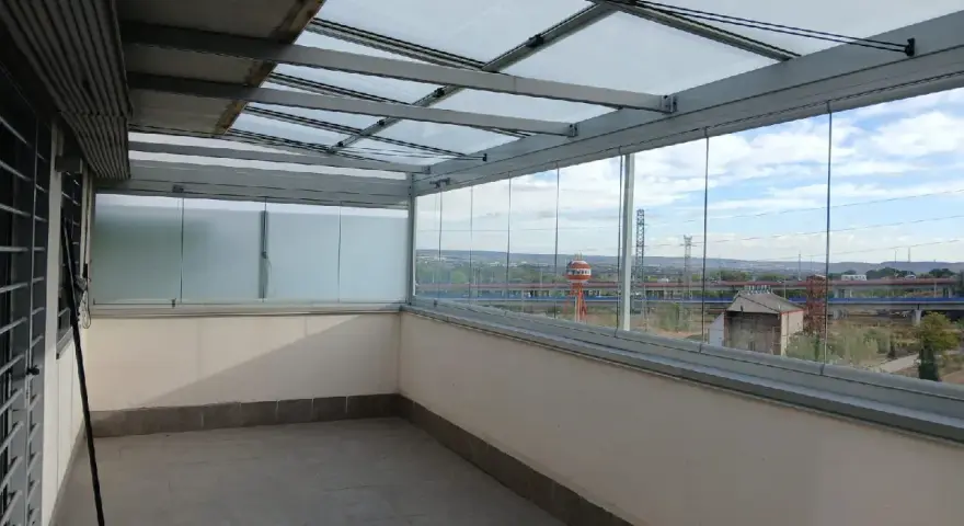Terraza con diversos tipos de cerramientos: acristalamiento corredero y techo de cristal.