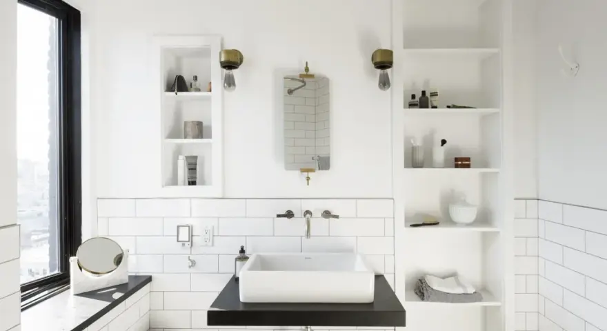 Modern bathroom with a white rectangular lavabo sobre mueble de madera oscura. Estanterías blancas a los lados.