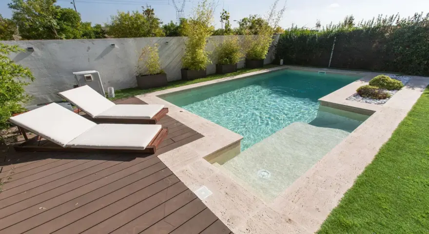 Modern pool with deck, lounge chairs, and bamboo plants. Great ideas para decorar alrededor de la piscina para un oasis de verano.