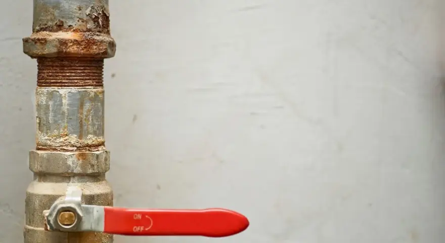 Tubería oxidada con llave de paso roja, lista para cambiar llaves de paso antiguas.
