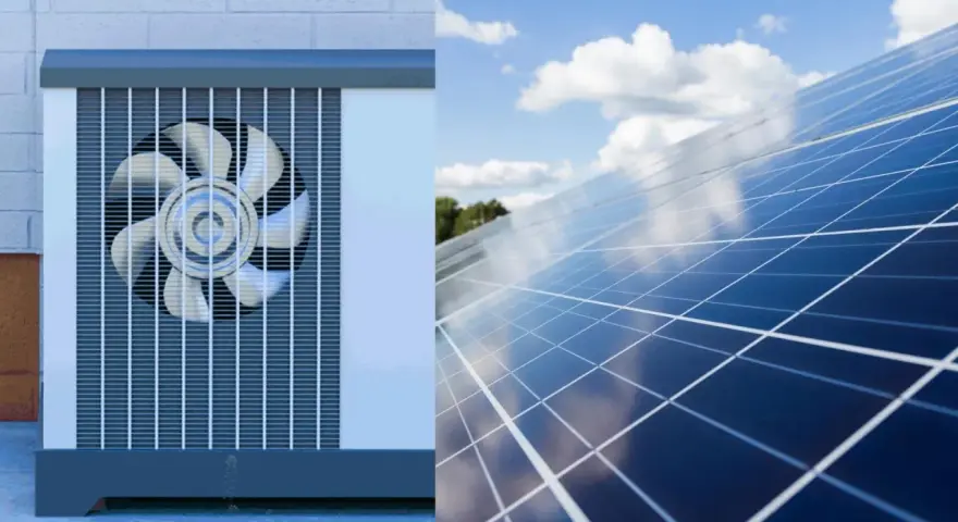 Unidad exterior de aerotermia junto a un campo de placas solares bajo un cielo azul con nubes.