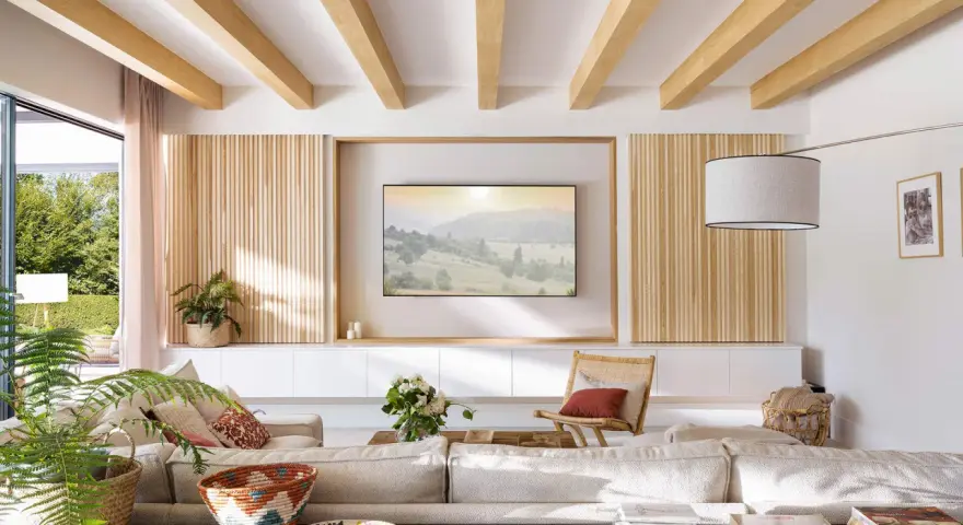 Salón moderno con palilleria en pared, vigas de madera en techo y sofá modular.