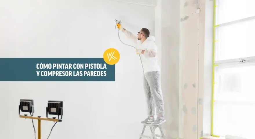 Hombre con traje protector pintando una pared con pistola y compresor.