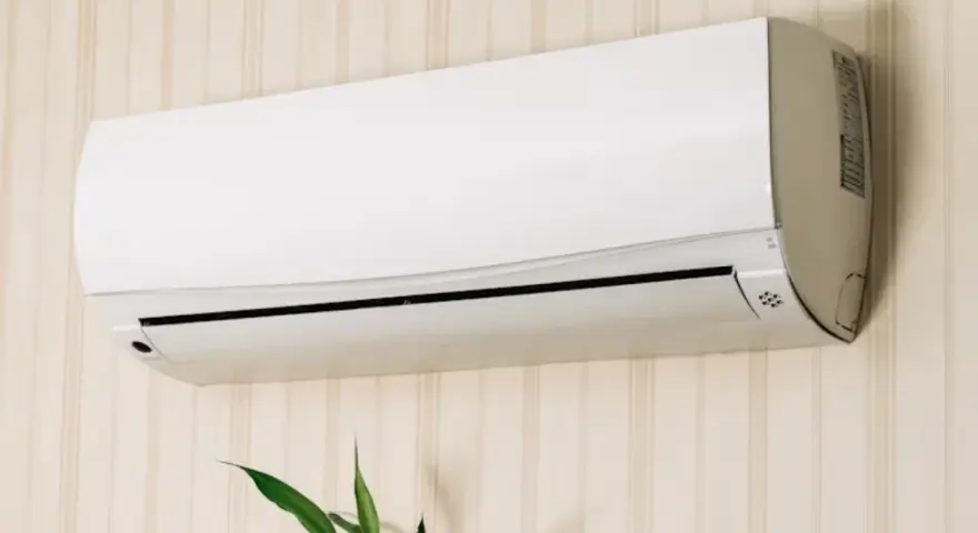 Un aire acondicionado blanco montado en una pared con papel tapiz. Averigua cuanto consume un aire acondicionado para ahorrar energía.