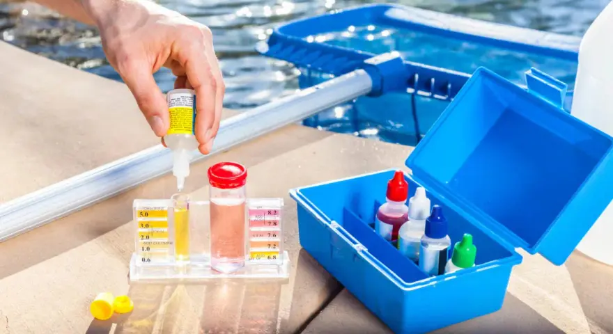 Persona usa un kit para medir el cloro y el pH de la piscina. Se puede echar cloro a una piscina de sal.