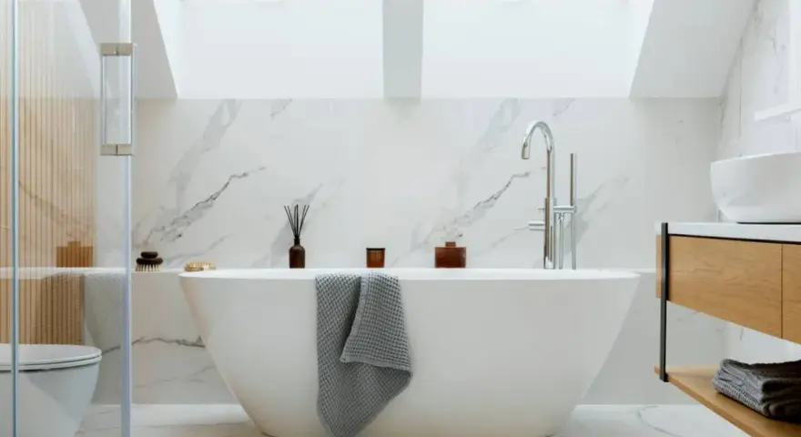 Baño moderno con bañera exenta, grifería cromada y revestimiento de mármol. Ideal para instalar bañera y disfrutar de un oasis de paz.
