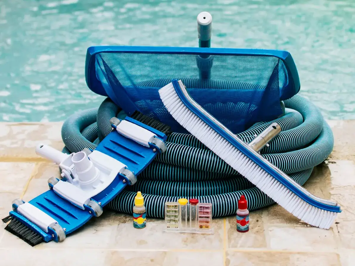Herramientas para el mantenimiento de piscinas: aspiradora, recogehojas, cepillo, manguera y kit de an&aacute;lisis de agua.