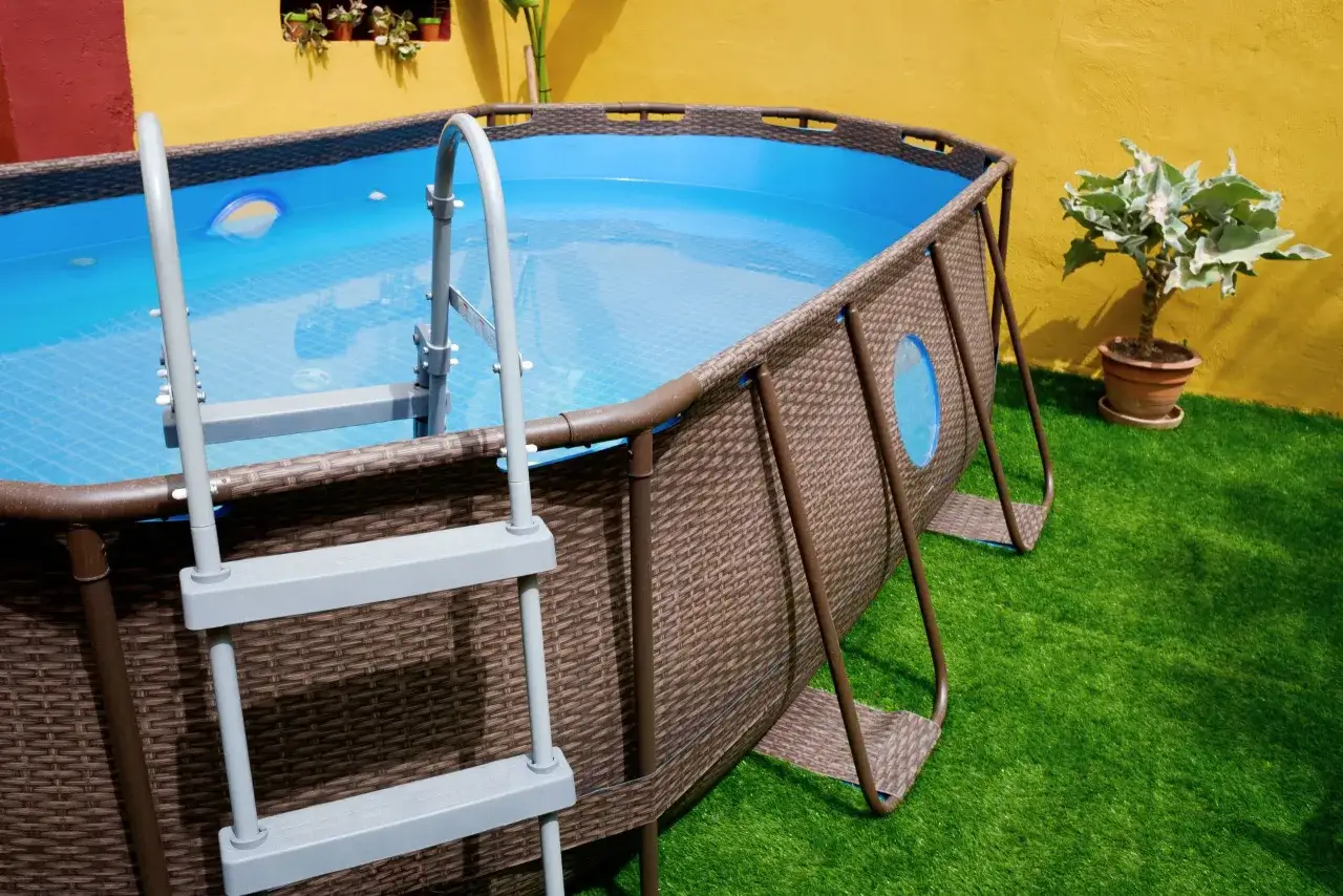 Piscina elevada sobre c&eacute;sped artificial, lista para el verano. La colocaci&oacute;n del c&eacute;sped artificial es clave para un acabado perfecto.