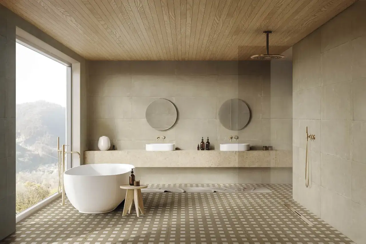 Ba&ntilde;o moderno con ba&ntilde;era exenta, lavabos dobles y ducha. El alicatar ba&ntilde;o con baldosas de gran formato y suelo a cuadros crea un ambiente sereno.