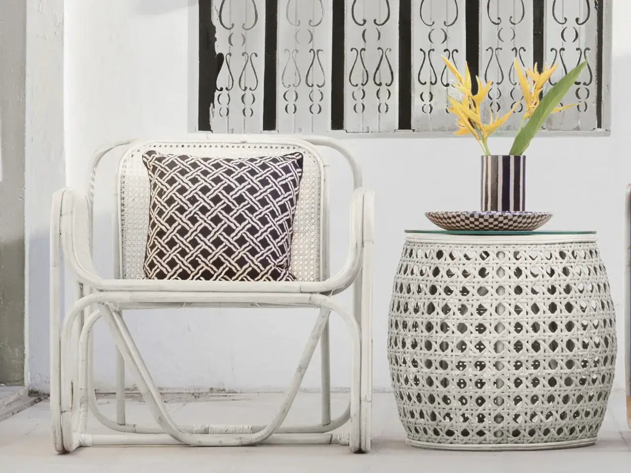 Sill&oacute;n y mesa auxiliar de mimbre blanco, con coj&iacute;n estampado y flores amarillas. Ideas de colores para pintar mimbre.