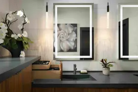 Elegante tocador con espejo iluminado, lavabo empotrado y orquídeas. Ideal para calcular el precio reforma baño 4 m2.
