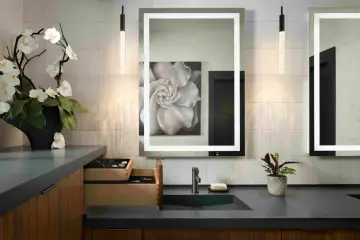 Elegante tocador con espejo iluminado, lavabo empotrado y orquídeas. Ideal para calcular el precio reforma baño 4 m2.