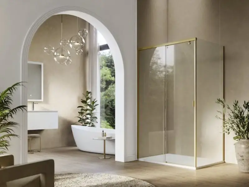 Mampara de ducha moderna con perfil dorado, un ejemplo de los tipos de mamparas de ducha que combinan estilo y funcionalidad en un baño elegante.